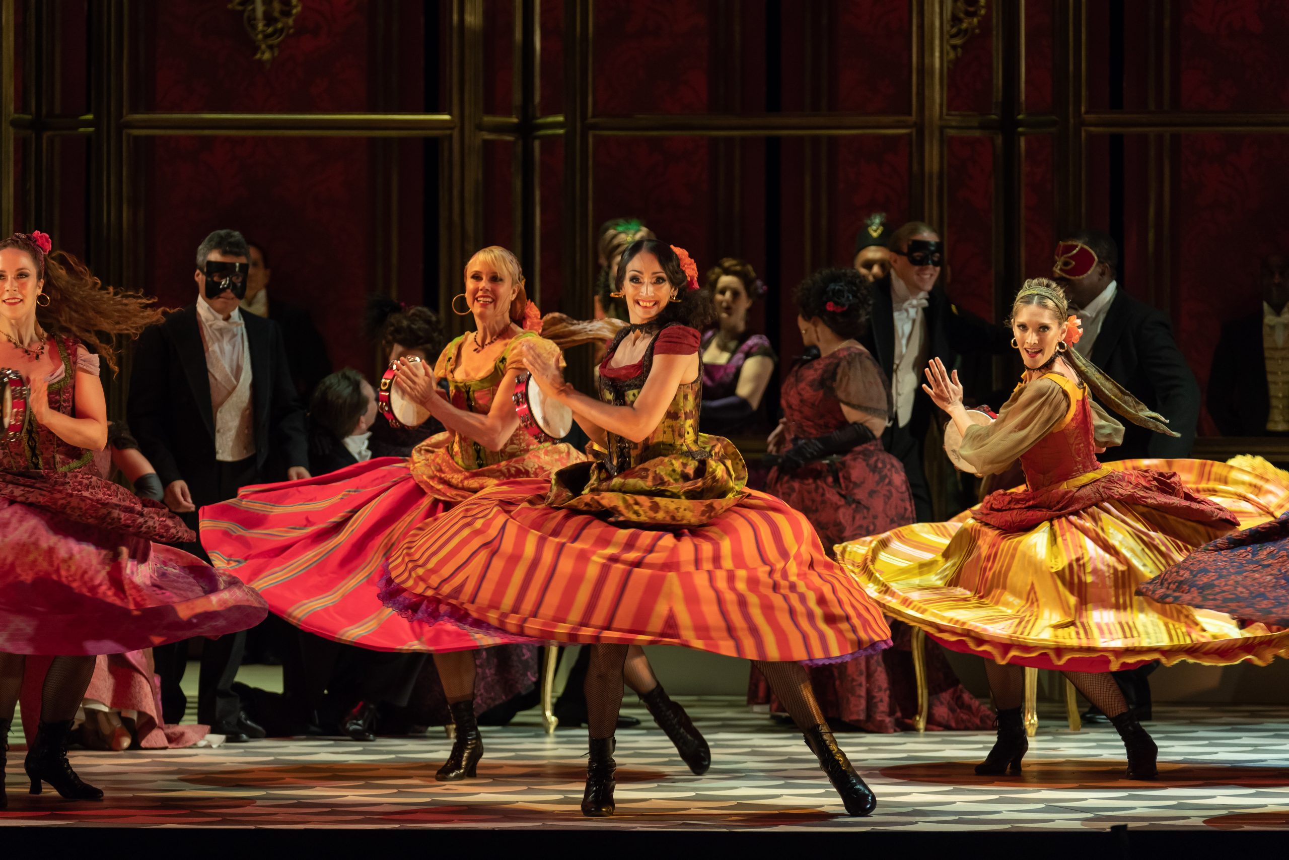 stage image of la traviata. women in colorful skirts dance