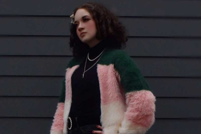 a teenage girl in a pink and white jacket