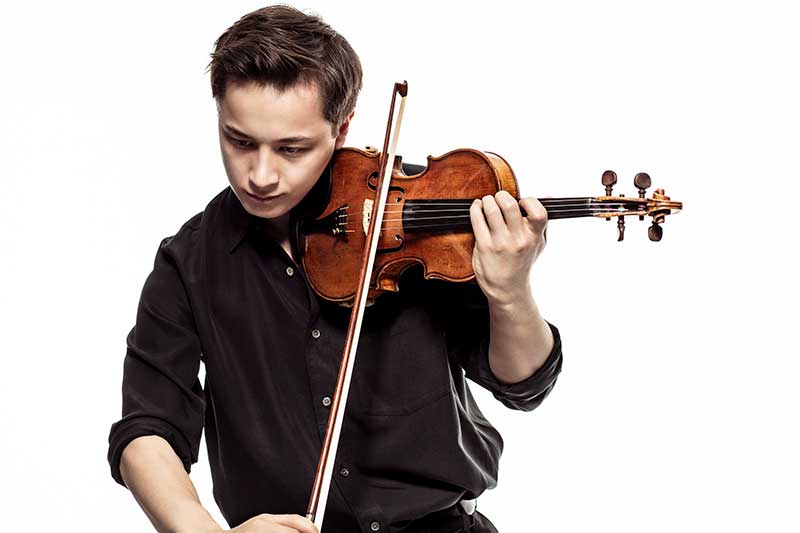 Johan Dalene, a young violinist wears a black shirt and plays the violin