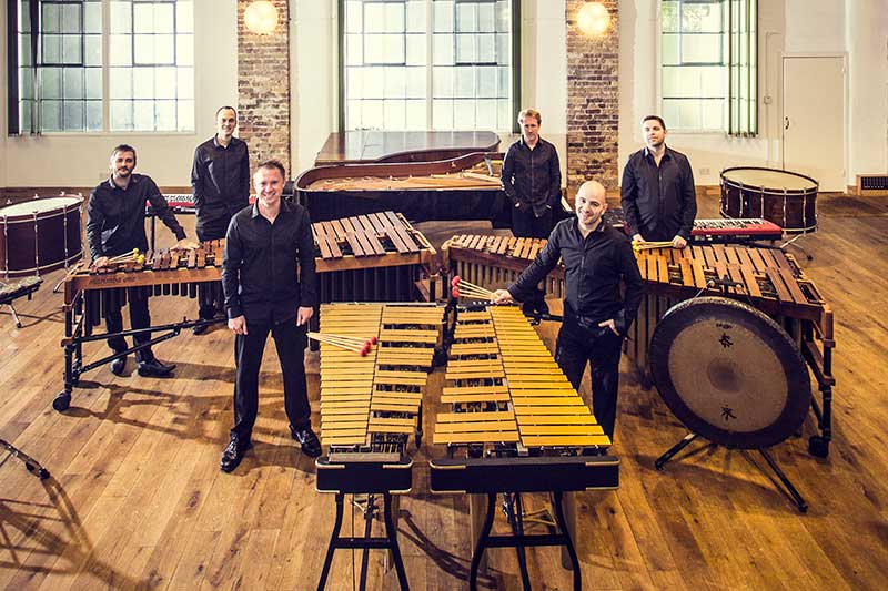 the colin currie group stand in a large room with all their instruments