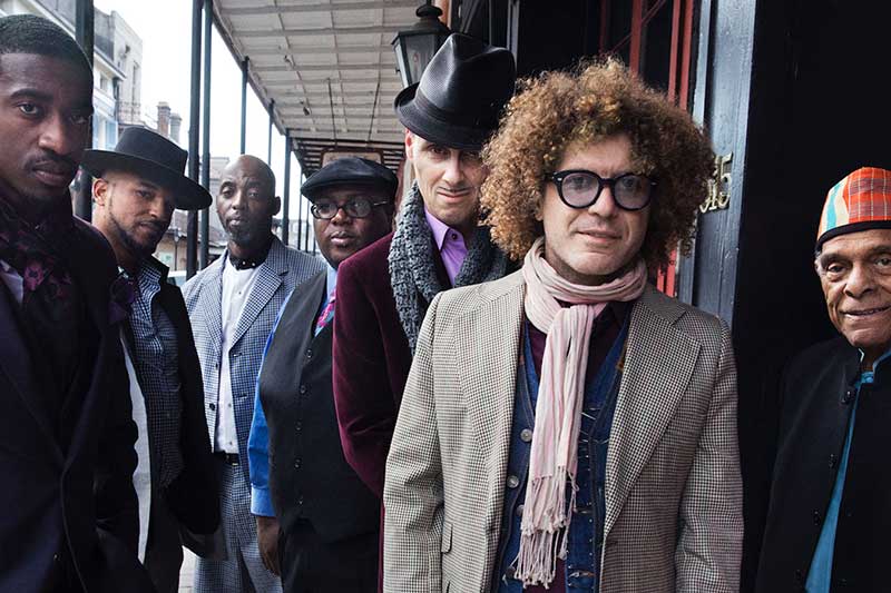 a group of men stand together outside. a group shot of preservation hall jazz band