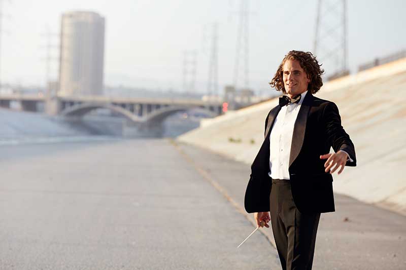 A white man wearing a tux stands in the empty river channels