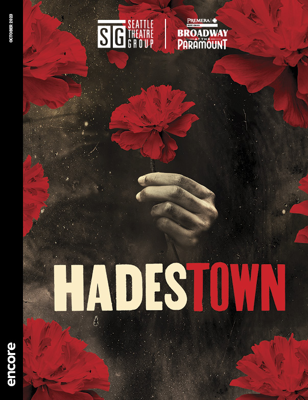 Hand holding a red rose on a dark background, surrounded by red roses | Cover of Hadestown at STG’s Broadway at the Paramount