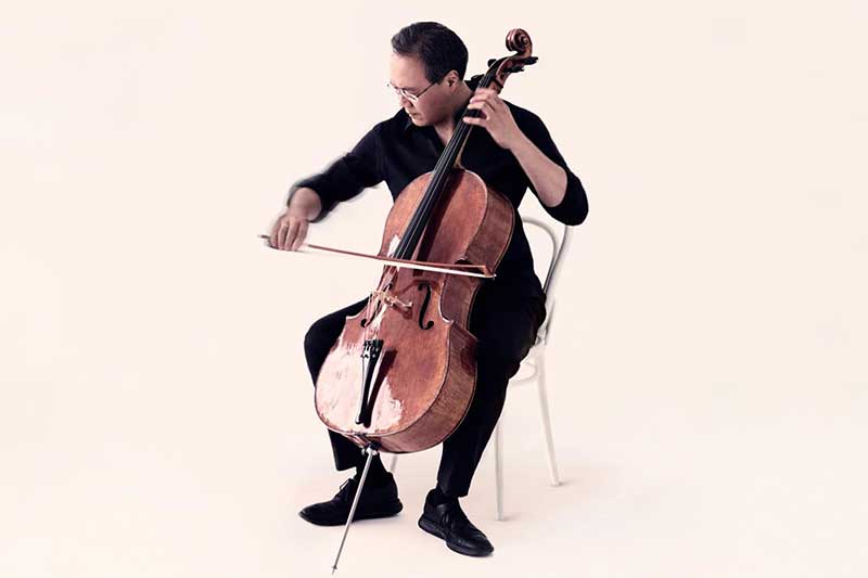 Yo-Yo Ma plays the cello in front of a white background.