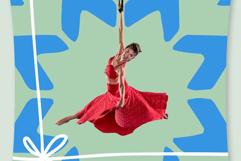 A woman in a red dress spins around hanging from a bar.