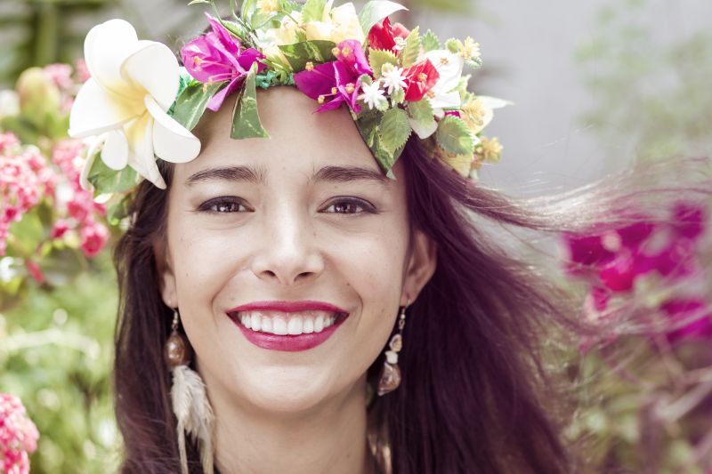 Image of a woman smiling wearing a flower crown.