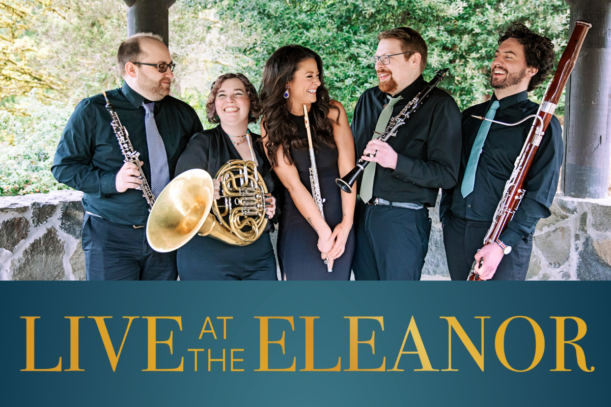 A group of musicians stands smiling with their instruments.