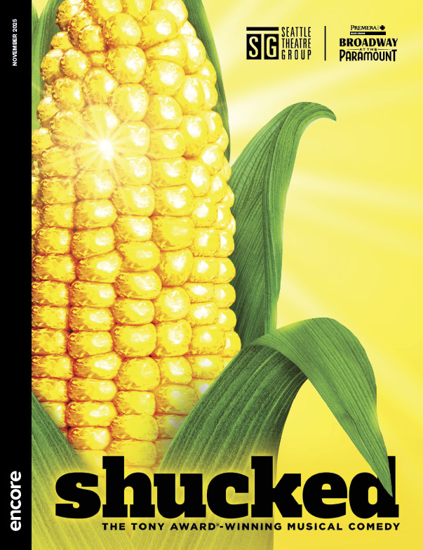 A half-husked ear of corn rises from the bottom of the page over a glowing yellow background. | Cover of Shucked for Broadway at the Paramount, November 2025