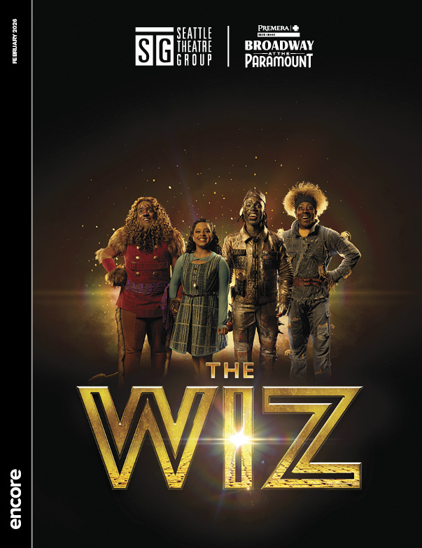 Dorothy and friends on a black backdrop with a golden glow behind them looking forward. | Cover of The Wiz for Broadway at the Paramount, February 2026